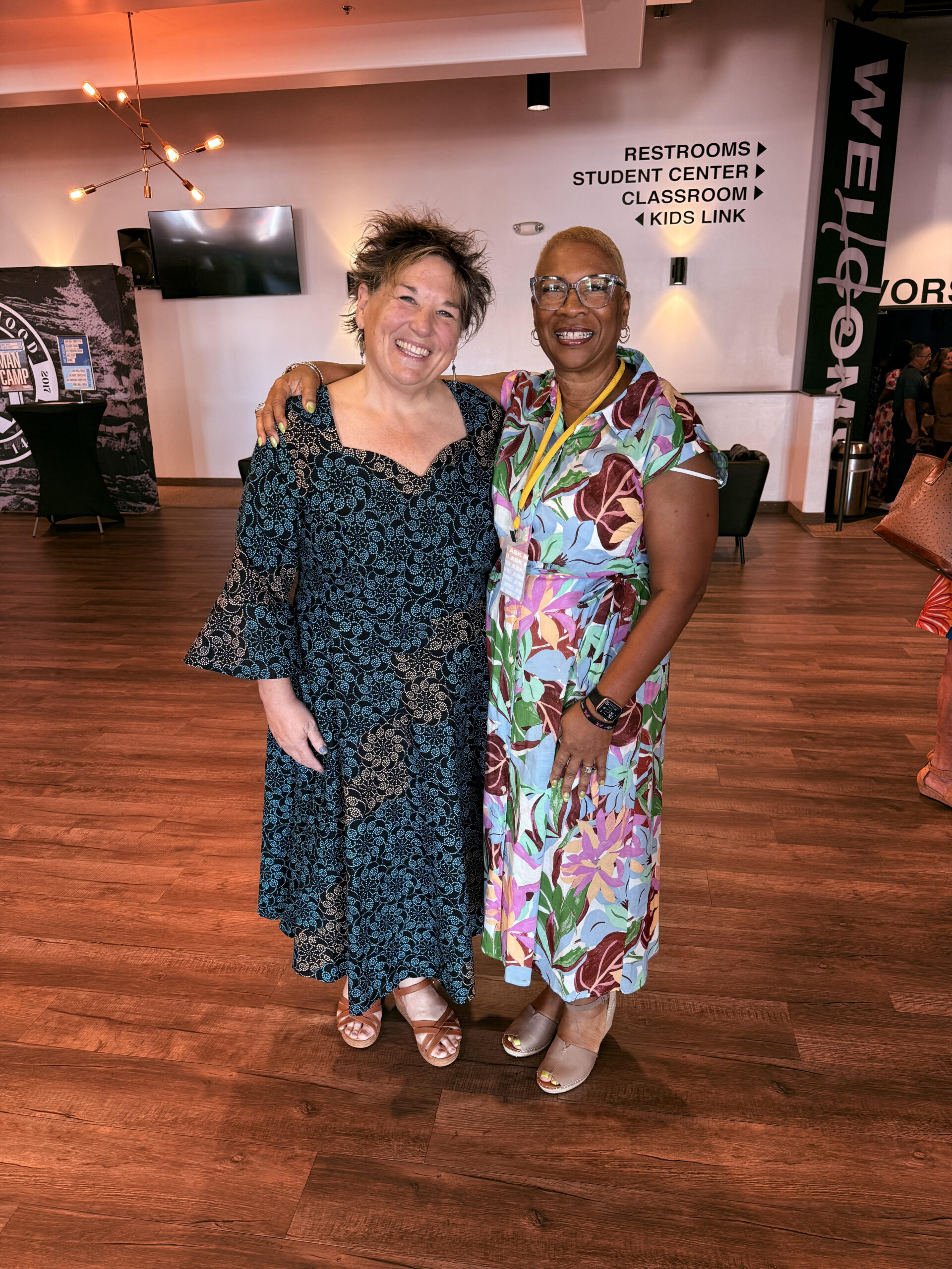 Two women arm-in-arm at a sisterhood gathering
