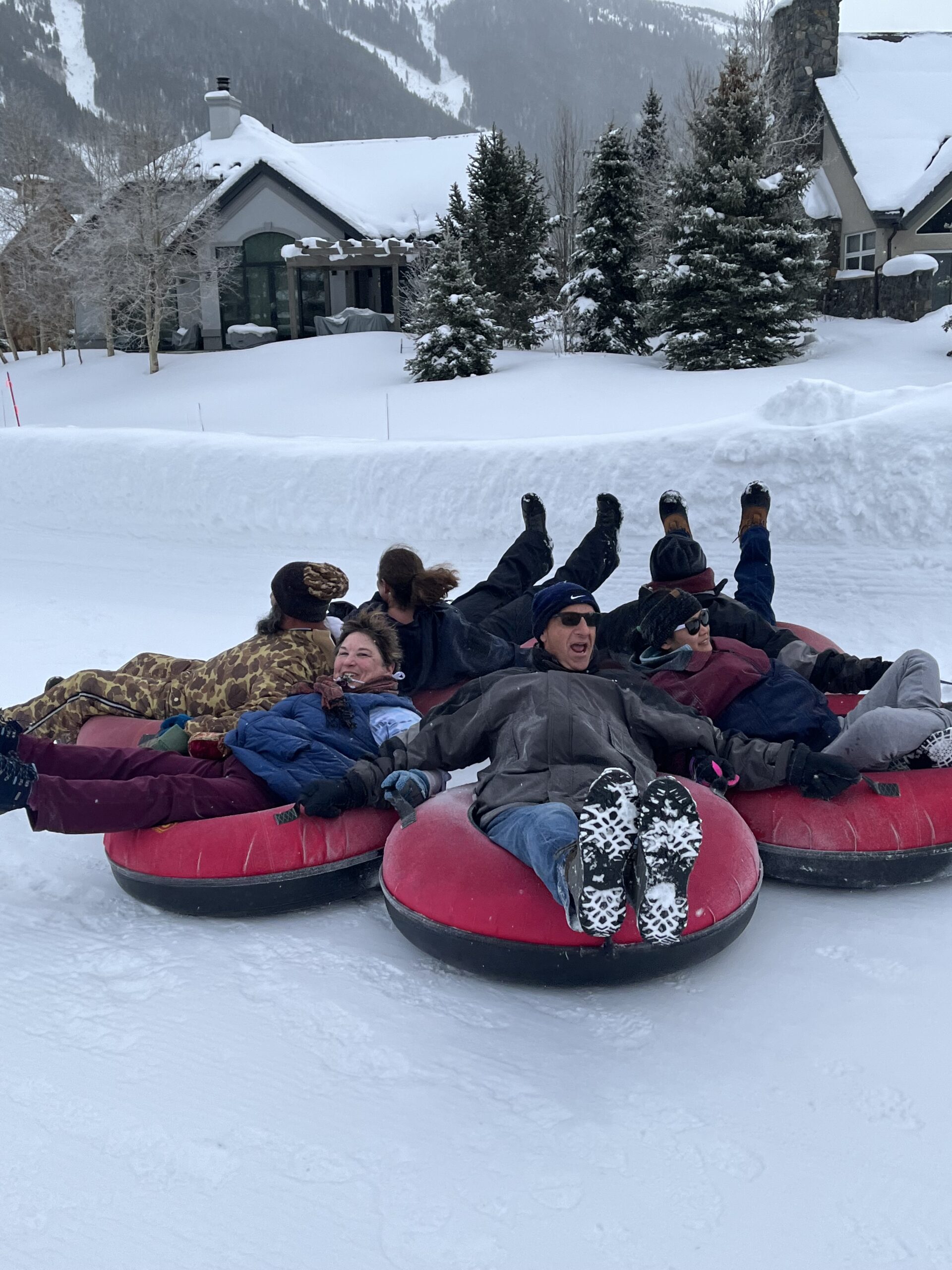 The group laughing on snow tubes at a Breckenridge Lion’s Path week