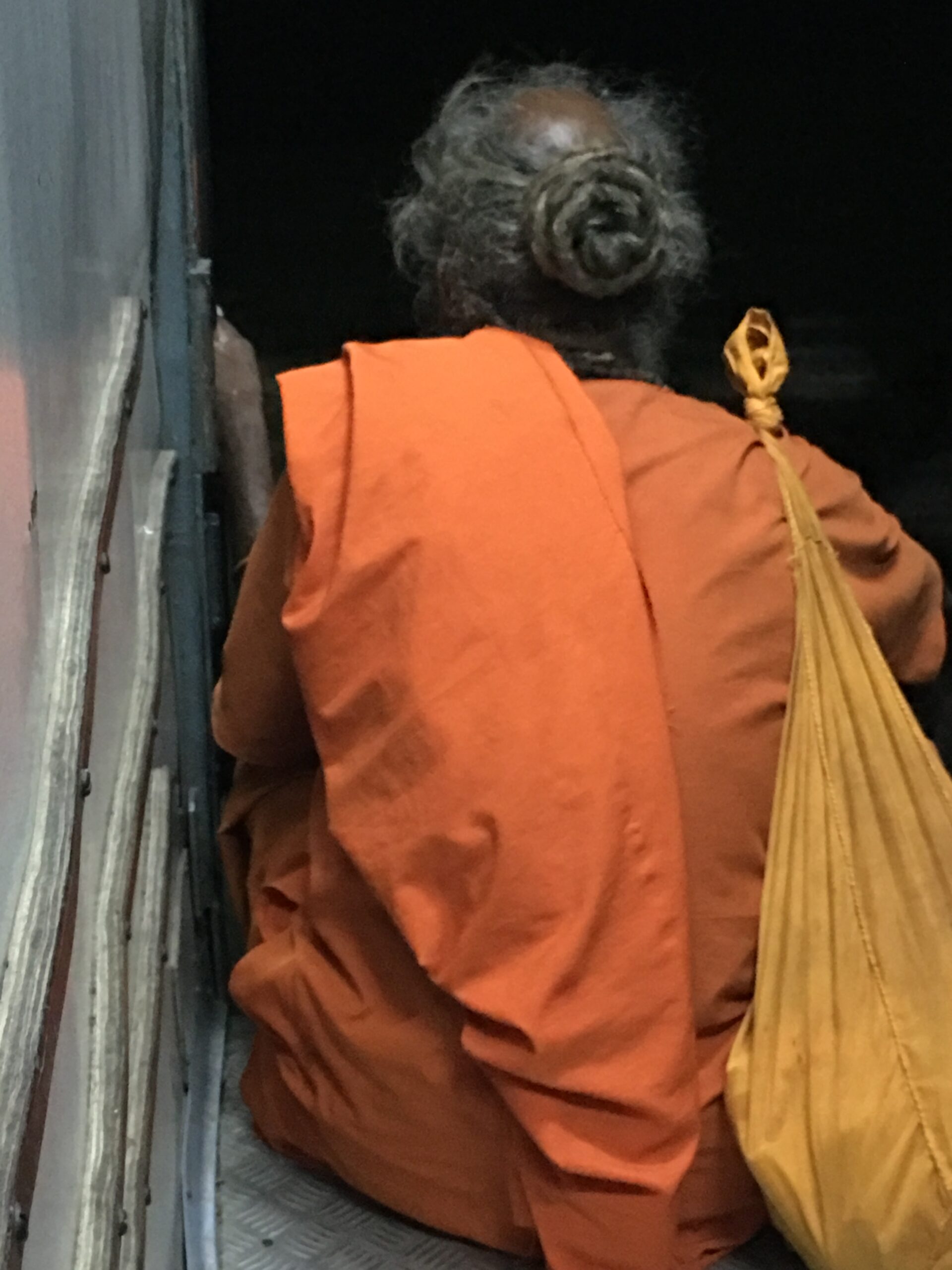 Man in orange robes, train